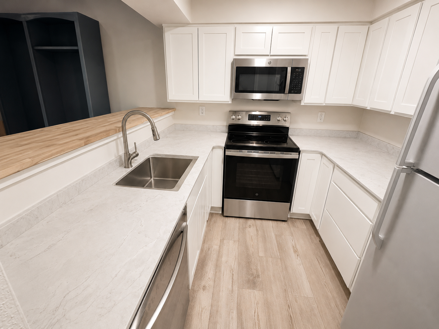 Completed kitchen renovation with new cabinetry, countertops, flooring, and appliances.